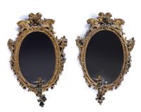 Paire de miroirs de forme ovale en bois mouluré sculpté et d…