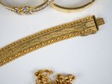 two gold bracelets and a gold bracelet with a diamond clasp