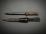 two knives are laying side by side on a gray surface