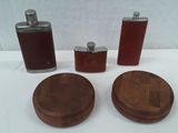 three flasks and a wooden coaster on a table