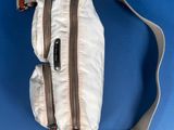 an overhead view of a white fanny bag on a blue background