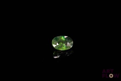 a close up of a green gems on a black surface