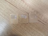 two stamps sitting on a wooden table with one stamp missing