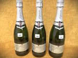 trois bouteilles de champagne sont alignées sur une table