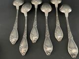 six silver spoons on a table with a black background