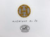 a close up of a plate with a gold and white design on it