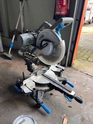 une photo d'une scie à onglet posée sur un support dans un garage