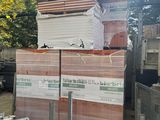 une pile de cartons posée sur une palette dans une cour