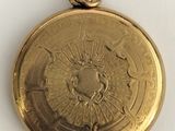 an image of a gold colored pocket watch on a white surface