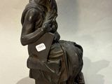 statue of a man sitting on a bench with a book