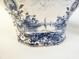 a blue and white vase with a picture of a boat in the water