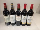 six bottles of red wine are lined up on a counter