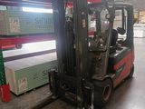 a forklift in a warehouse with many boxes on the floor