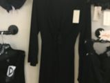 a black dress on a hanger in a clothing store