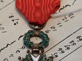 a red ribbon with a gold star on top of it