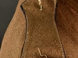 a close up of a brown jacket with a button on it