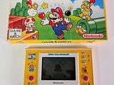 console de jeux portable Nintendo jaune avec le jeu et le mode d'emploi de « Mario et les Goooies »