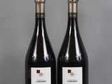two bottles of wine sitting on top of a table next to each other