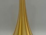 a gold vase sitting on a table with a white background
