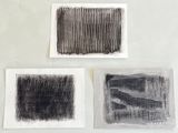 trois dessins en noir et blanc sur papier blanc posés sur une table