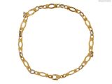 gros plan d'un bracelet en or sur fond blanc