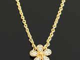 a diamond flower pendant on a gold chain