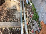 a pile of wood sitting on the ground next to a wall
