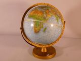 un globe terrestre posé sur un socle, sur une table