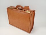 brown leather suitcase with two handles sitting on a white surface