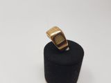 a gold ring sitting on top of a black ring holder