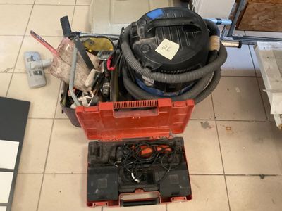 a red box with a vacuum on it and tools on the floor