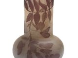 un vase en verre orné de feuilles sur fond blanc