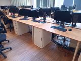 many computer screens on the desks in this office