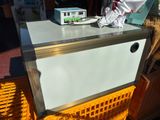 a white refrigerator sitting on top of a yellow crate