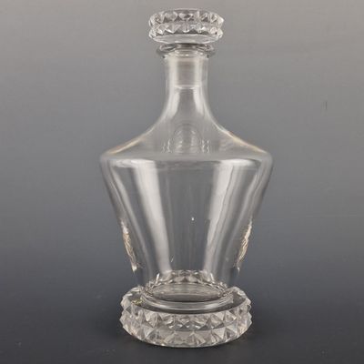 a clear glass bottle with a crown on the top
