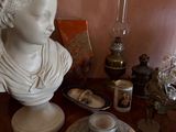 a bust of a woman sitting on a table next to a candle