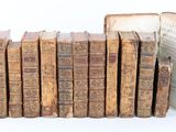 plusieurs vieux livres sont empilés sur une surface blanche