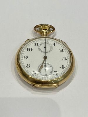 a gold pocket watch sitting on a white surface