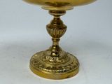 a gold cup sitting on top of a white table