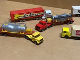 Plusieurs camions miniatures sont alignés sur une surface marron