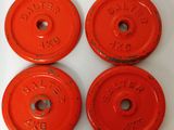 four red cast iron weights on a white surface