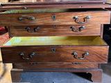 a wooden chest of drawers with a mirror on top of it