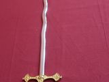 a sword on a table with a red table cloth