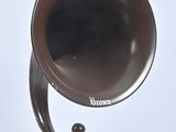 un gramophone à l'ancienne posé sur un support, sur fond blanc