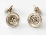 a close up of a pair of silver buttons on a white surface