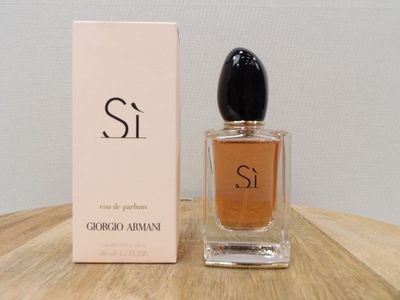 une photo d'un flacon de parfum posé sur une table en bois