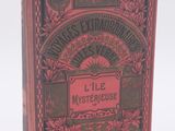 un vieux livre à la couverture rouge posé sur une surface blanche