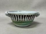 a green and white bowl sitting on a table