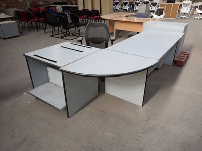 un bureau blanc avec une chaise noire au milieu
