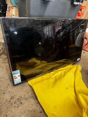 un téléviseur posé par terre à côté d'un tissu jaune
